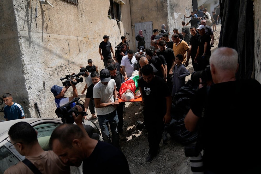 Palestinian mourners carry the body of Ayed Abu Al-Hija, 64, who was killed during the recent Israeli aggression in the occupied West Bank, during his funeral in the refugee camp of Nur Shams, Tulkarm, occupied Palestine, August 30, 2024 (AP)