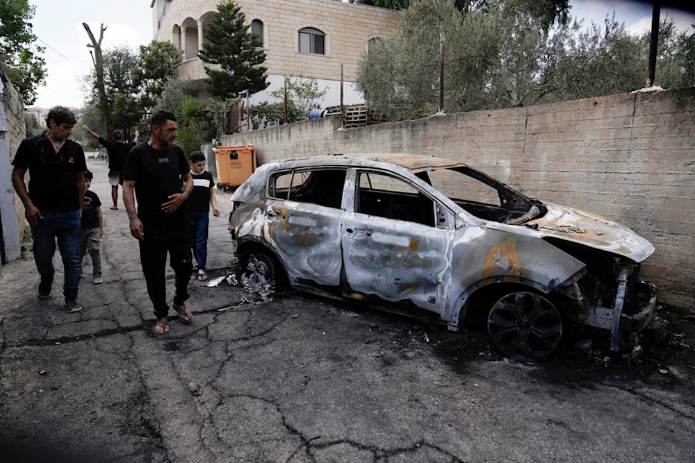 Palestinians check a damaged car following a military operation in the West Bank town of Zababdeh, south of Jenin, Friday, Aug. 30, 2024. (AP Photo/Majdi Mohammed)