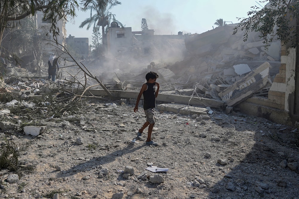 A Palestinian boy walks past the rubble of a school destroyed in an Israeli airstrike on Deir al-Balah, central Gaza Strip, Saturday, July 27, 2024. (AP)