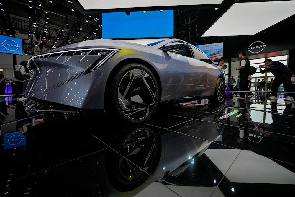 A visitor takes a photo of a Nissan EVO Concept car model on display during the Auto China 2024 in Beijing, Sunday, April 28, 2024. (AP)