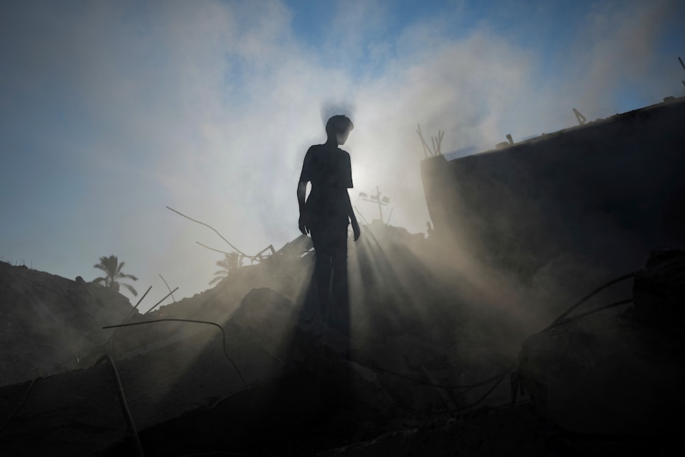 A Palestinian child inspects the rubble of a school destroyed in an Israeli airstrike on Deir al-Balah, central Gaza Strip, Saturday, July 27, 2024. (AP)