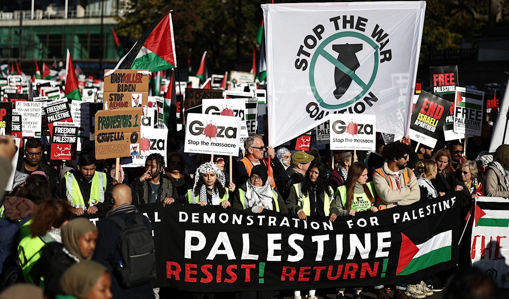 Pro-Palestinian protesters gather with placards and flags, including a banner urging Resist! Return!, at a 'National March For Palestine' in central London on November 11, 2023. (AFP)