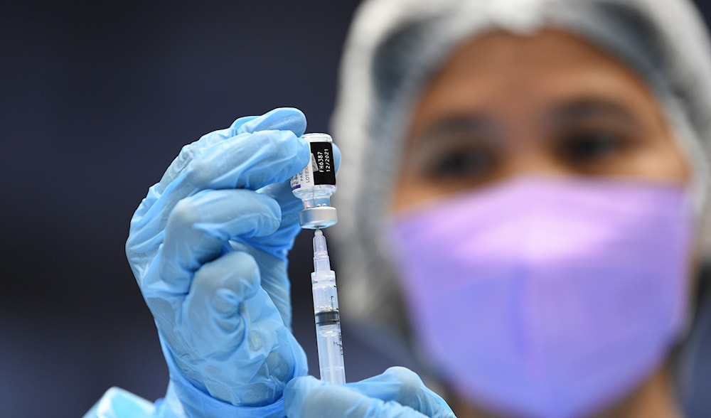 A medical worker prepares a syringe of the Pfizer-BioNTech COVID-19 vaccine in a suburb of Manila on November 29, 2021. (AFP)