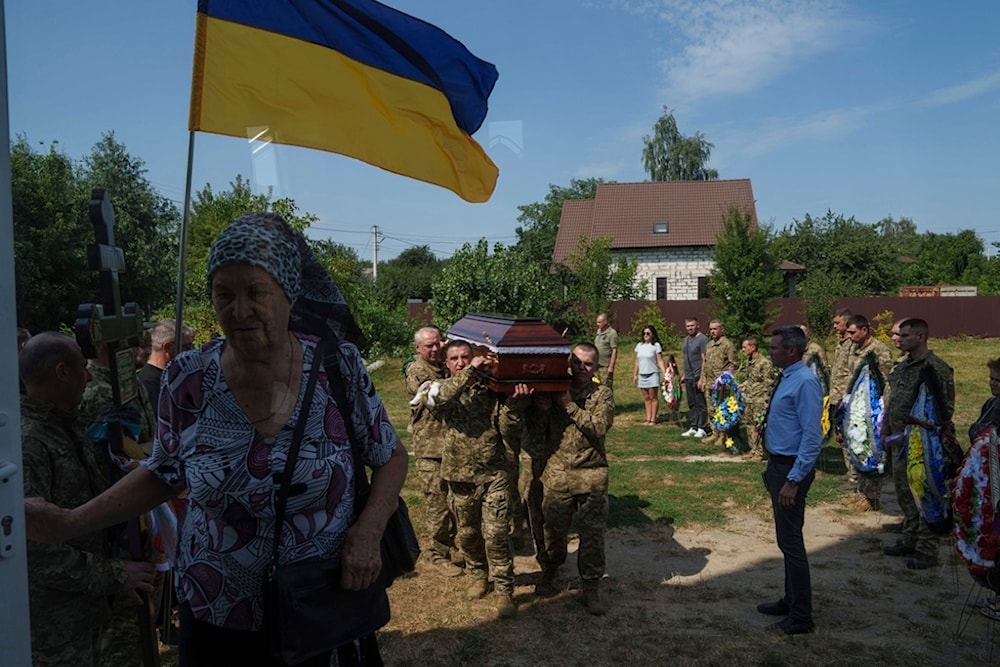 A guard of honour carry the coffin of their comrade Volodymyr Grechanyi, a Ukrainian serviceman, during the funeral ceremony in the village of Putrivka, Ukraine, Thursday, Aug. 1, 2024.  (AP)