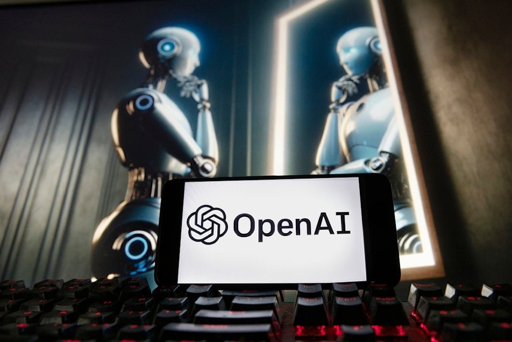 The OpenAI logo is displayed on a cell phone with an image on a computer monitor generated by ChatGPT's Dall-E text-to-image model, Dec. 8, 2023, in Boston. (AP)