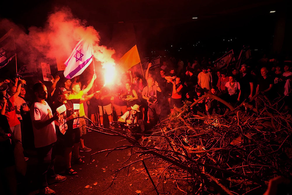 People block a road as they protest calling for a deal for immediate release of captives held in the Gaza Strip, in Tel Aviv, occupied Palestine, Sunday, September 1, 2024 (AP)