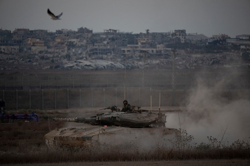 Israeli soldiers move on the top of a tank near the Israeli-Gaza border, as seen from southern occupied Palestine, Wednesday, August 21, 2024 (AP)