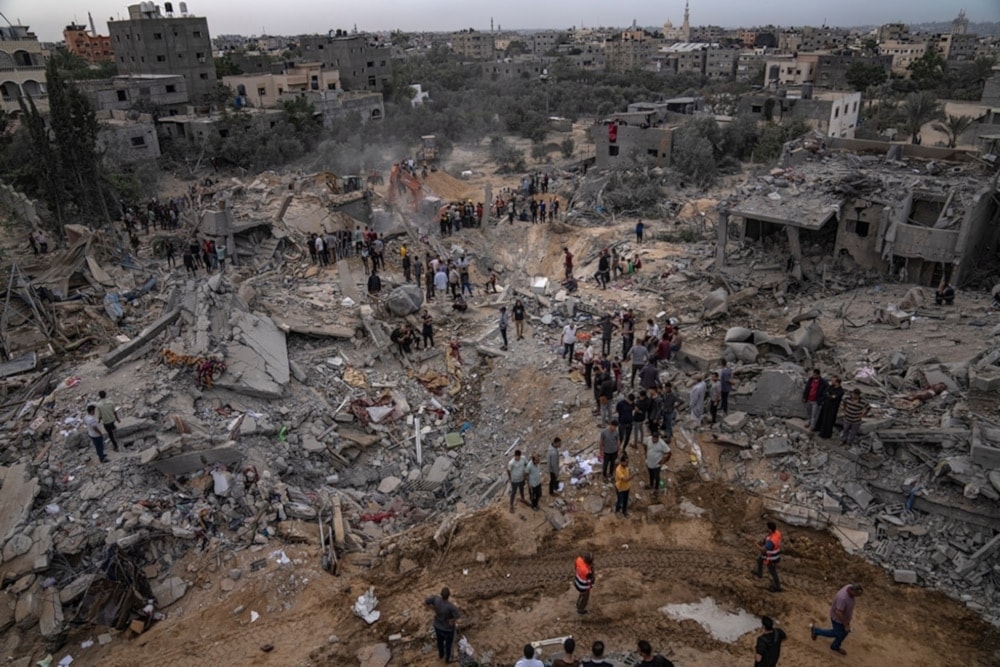 Palestinians look for survivors under the rubble of a residential area bombarded by Israeli warplanes in Khan Younis, southern Gaza Strip, November 12, 2023 (AP)