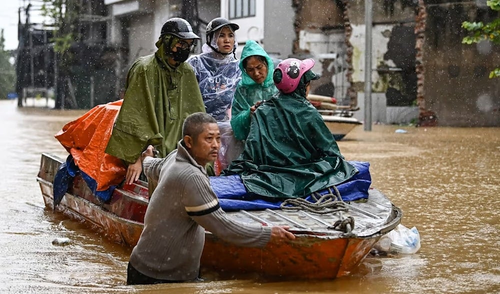 Local residents are evacuated on a boat through flood waters caused by Typhoon Yagi in Hanoi on September 11, 2024. (AFP)