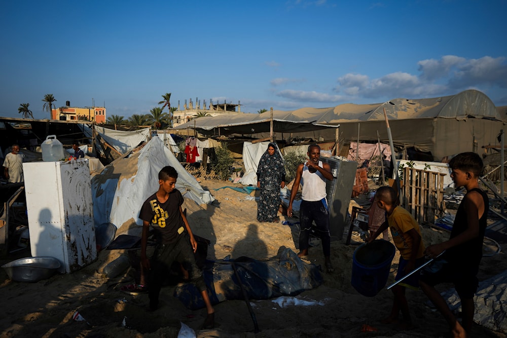 Palestinians look at the destruction after an Israeli airstrike on a crowded tent camp housing Palestinians displaced by the war in Muwasi, Gaza Strip, on September 10, 2024. (AP)