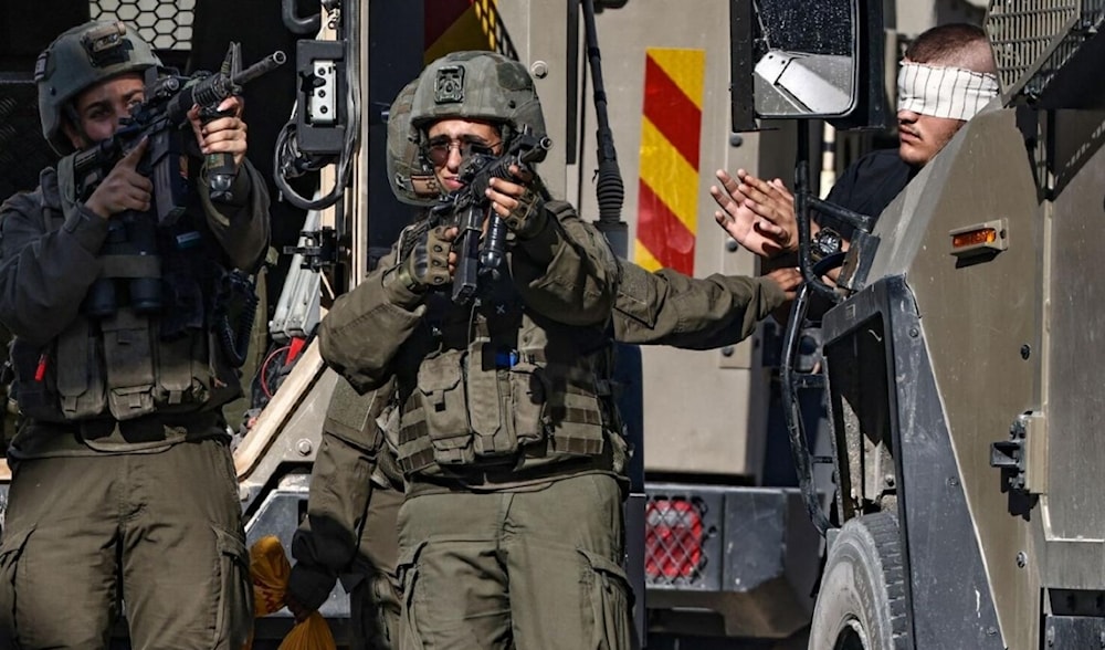 IOF soldiers point their guns as they arrest a blindfolded Palestinian during an ongoing military operation in Tubas in the north of the occupied West Bank on September 11, 2024. (AFP)