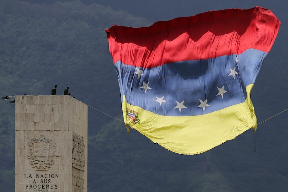 A Venezuelan national flag strung from The Walk of the Heroes monument flutters in the wind before the start of an Independence Day military parade, in Caracas, Venezuela, Friday, July 5, 2024.