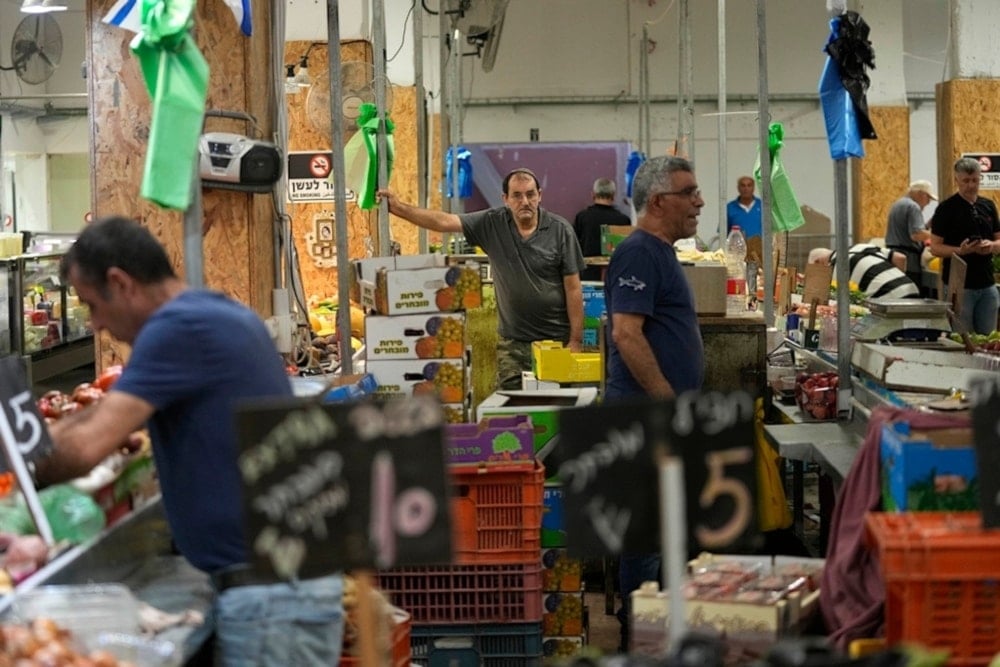 Vendors sell and vegetables in a market in Haifa, occupied Palestine, Monday, August 5, 2024. (AP)