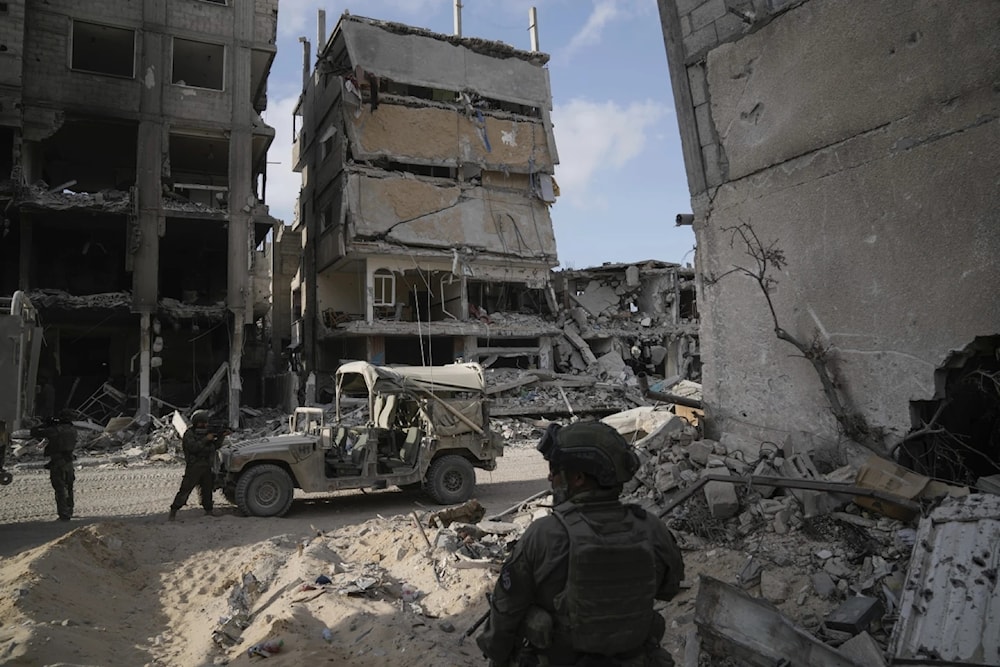 Israeli occupation take up position next to buildings destroyed by the Israeli military in the Gaza Strip on Friday, September 13, 2024. (AP)