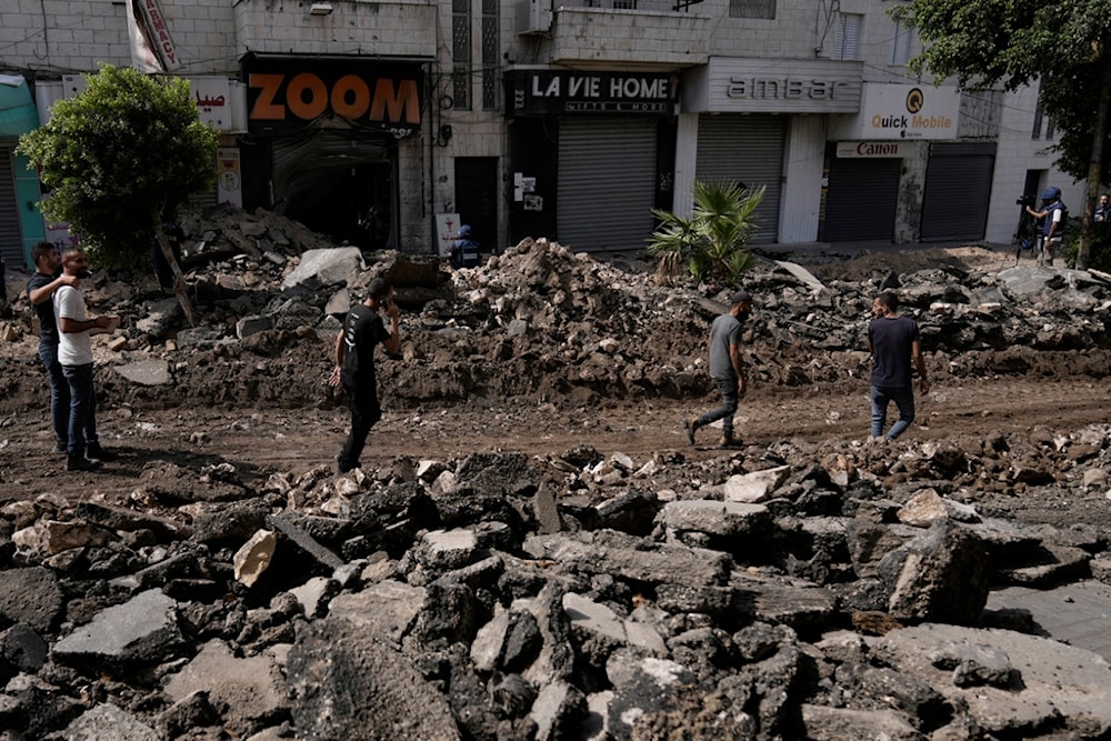 Palestinian walk on a street damaged during the Israeli incursion in the West Bank city of Jenin, Sunday, Sept. 1, 2024. (AP)