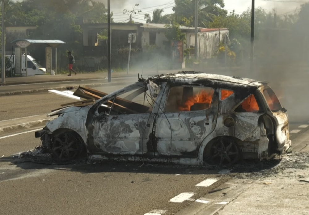 A car burns in Martinique on Tuesday following a night of riots amid protests over the high cost of living. (AFP/Getty Images)