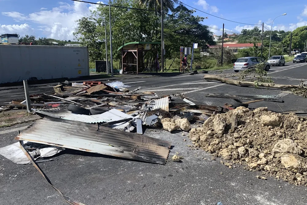 Debris left by demonstrators block a street of Le Gosier Sunday November 21, 2021. (AP)