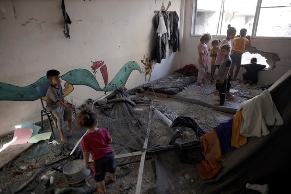 Palestinian children navigate heavy damage to a UNRWA school sheltering forcibly displaced Palestinians in Khan Younis, southern Gaza Strip, on Friday June 21, 2024. (AP) 