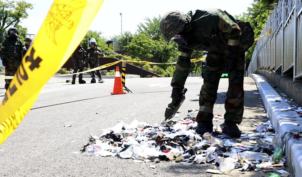  South Korean soldier wearing protective gears checks the trash from a balloon presumably sent by North Korea, in Incheon, South Korea, on June 2, 2024. (AP)