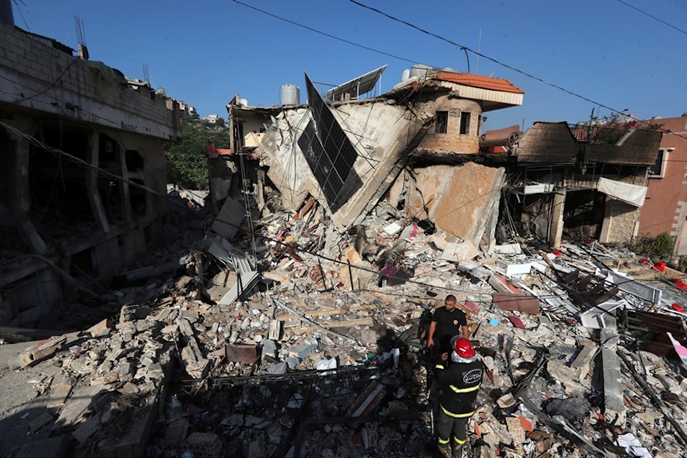 Rescuers stand on the rubble of a building hit in an Israeli airstrike in the southern village of Akbieh, Lebanon, Tuesday, Sept. 24, 2024 (AP Photo/Mohammed Zaatari)