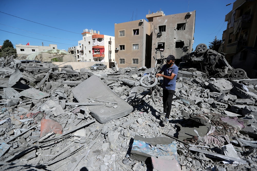 A man carries a damaged bicycle at the site of an Israeli airstrike in Saksakieh, south Lebanon, on September 26, 2024. (AP)