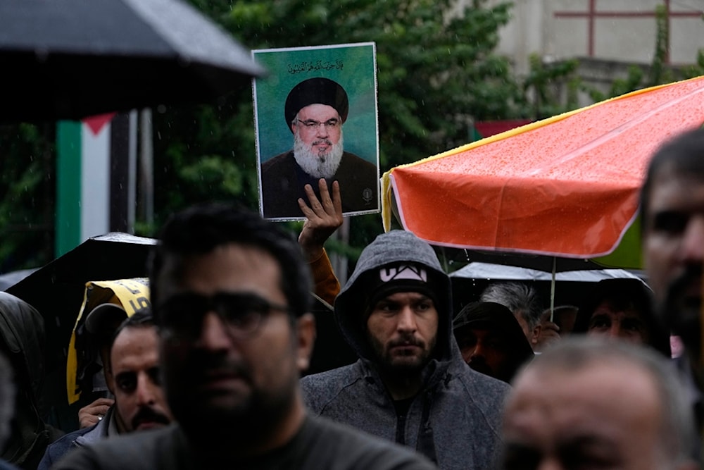 An Iranian demonstrator holds up a poster of Hezbollah Leader Sayyed Hassan Nasrallah in a gathering to support Hezbollah at the Felestin (Palestine) Square in downtown Tehran, Iran, September 28, 2024 (AP)