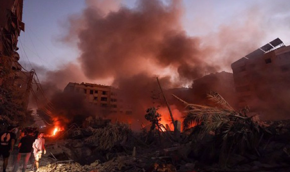 Smoke rises from the rubble as people gather at the scene of Israeli airstrikes in Beirut's southern suburb on September 27, 2024. (AFP)