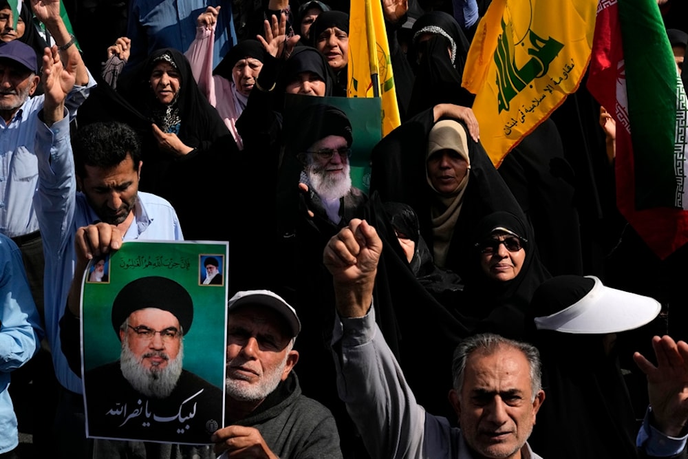 Iranians chant and hold posters of Supreme leader Ayatollah Ali Khamenei, center, and martyred Hezbollah Secretary-General Sayyed Hassan Nasrallah during an anti-Israeli rally after Friday prayers in Tehran, Iran, Friday, September 27, 2024 (AP)