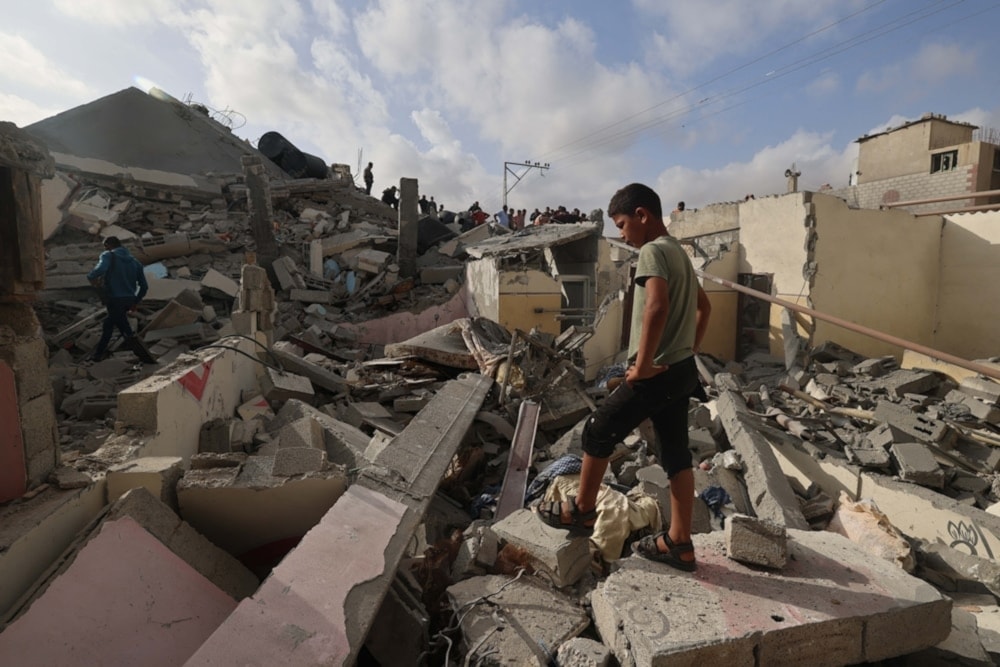 Palestinian child standing over the rubble of a building in Rafah destroyed by Israeli occupation bombing on Apirl 21,2024. (AFP)