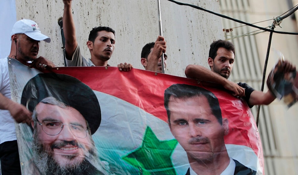 Demonstrators shout slogans as they hold portraits of Syrian President Bashar Assad and Hezbollah leader Hassan Nasrallah, in Beirut, Lebanon, on Thursday Aug. 11, 2011. (AP)