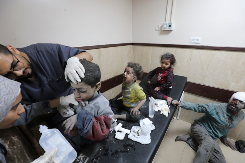 A Palestinian father and his three children wounded in an Israeli bombardment of the Gaza Strip are treated at al Aqsa Hospital on Deir al-Balah, Gaza, on November 21, 2023 (AP)