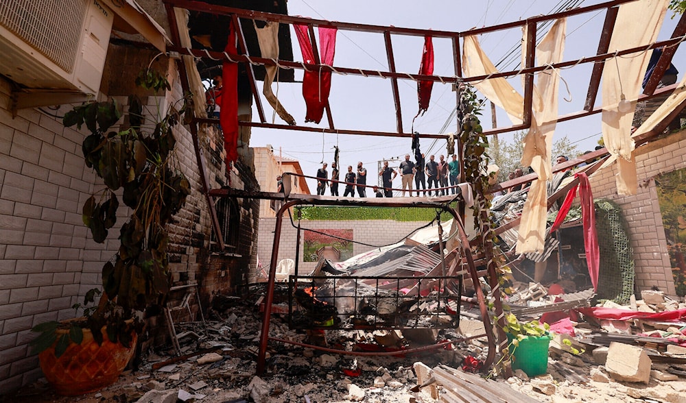 People assess the damage inflicted on a house during an Israeli raid in the West Bank city of Jenin on July 5, 2024. (AFP)