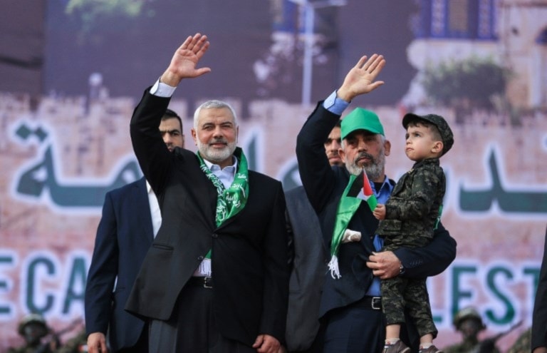 Martyr Ismail Haniyeh (L) and Hamas's leader in the Gaza Strip Yahya Sinwar wave during a rally marking the 30th anniversary of the founding of the resistance movement, in Gaza City, on December 14, 2017. (AFP)