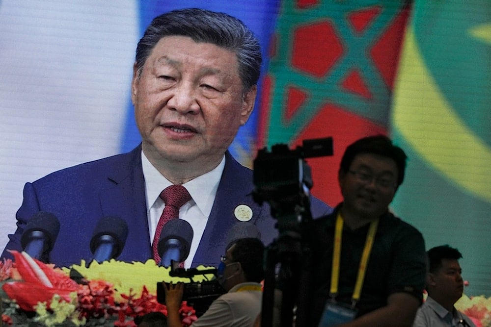 Cameramen film near a screen showing China's President Xi Jinping delivering an opening ceremony speech for the China Africa Forum, at the Great Hall of the People in Beijing, Thursday, September 5, 2024 (AP)