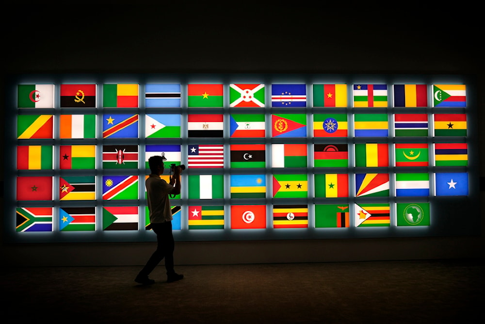 A cameraman films African national flags on display at the media center during the opening ceremony of the China Africa Forum, in Beijing, Thursday, Sept. 5, 2024. (AP Photo/Andy Wong)