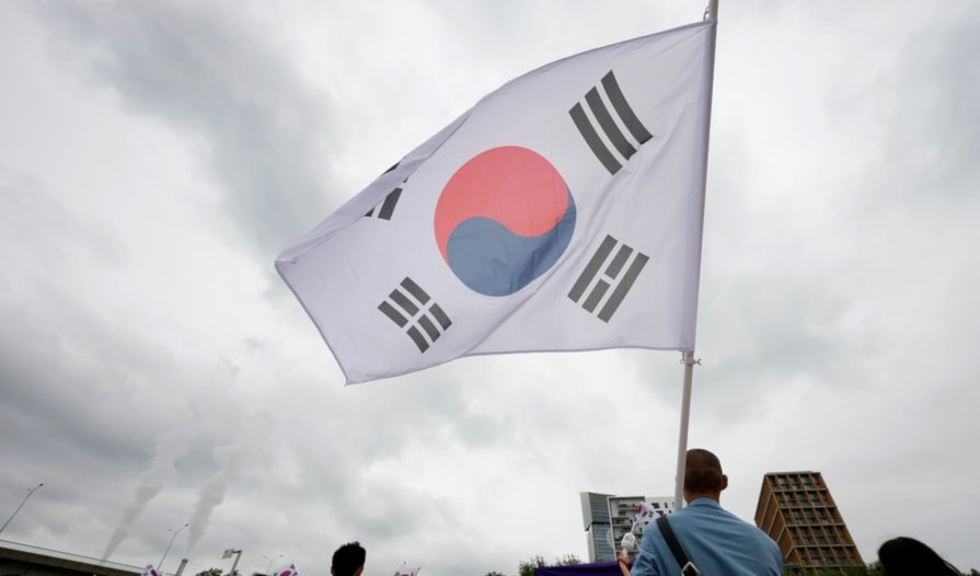 South Korea's olympic team waves from a boat, in Paris, France, during the opening ceremony of the 2024 Summer Olympics, Friday, July 26, 2024. (AP Photo/Lee Jin-man, Pool)