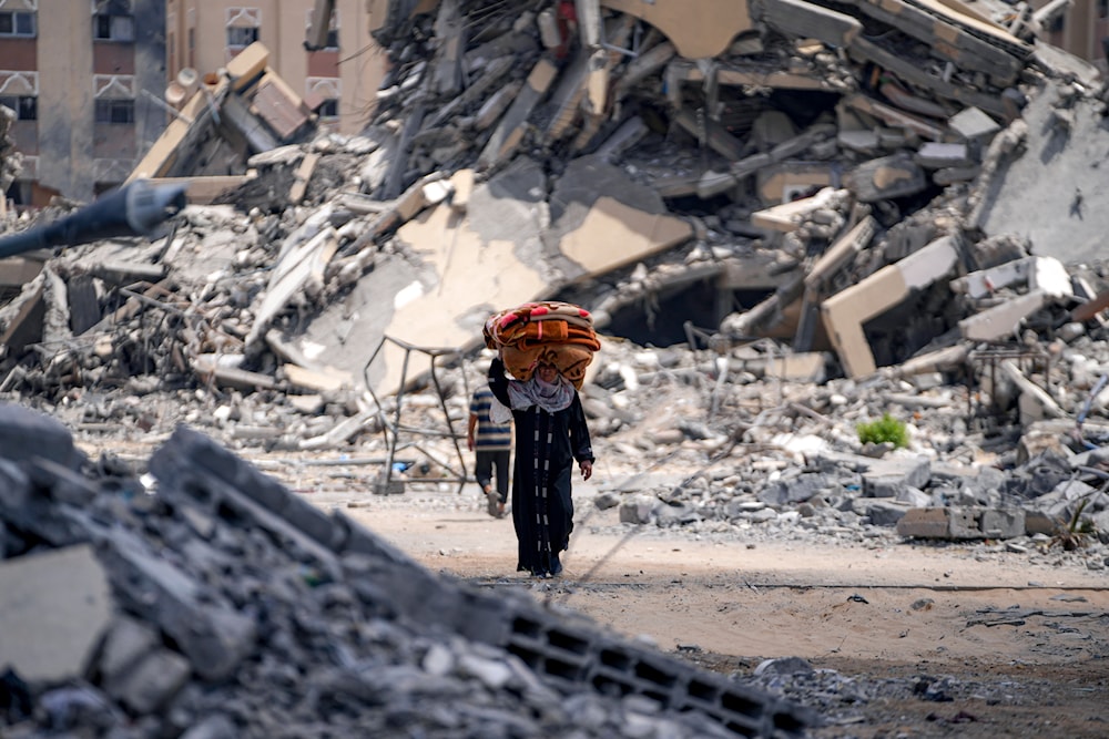 A Palestinian displaced woman by the Israeli air and ground offensive on the Gaza Strip flees from Hamad City, following an evacuation order by the Israeli army to leave parts of the southern area of Khan Younis, August 11, 2024. (AP)