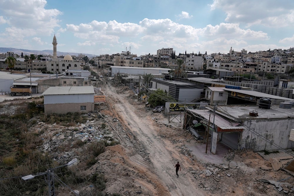 A man walks on a damaged road following an Israeli army raid in Jenin, West Bank, on September 4, 2024. (AP)