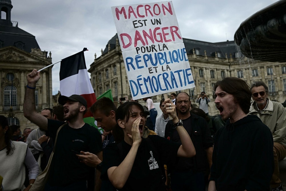 Protester holds a banner reading 