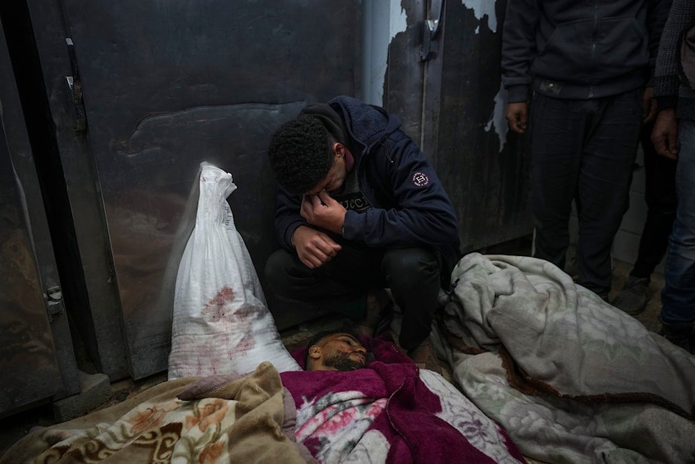 Kareem Al-Dabaji mourns his brother Anas Al-Dabaji, who was killed in an Israeli airstrike that hit an apartment in Deir Al-Balah, at Al-Aqsa Hospital morgue in Deir Al-Balah, Gaza, on January 9, 2025. (AP)