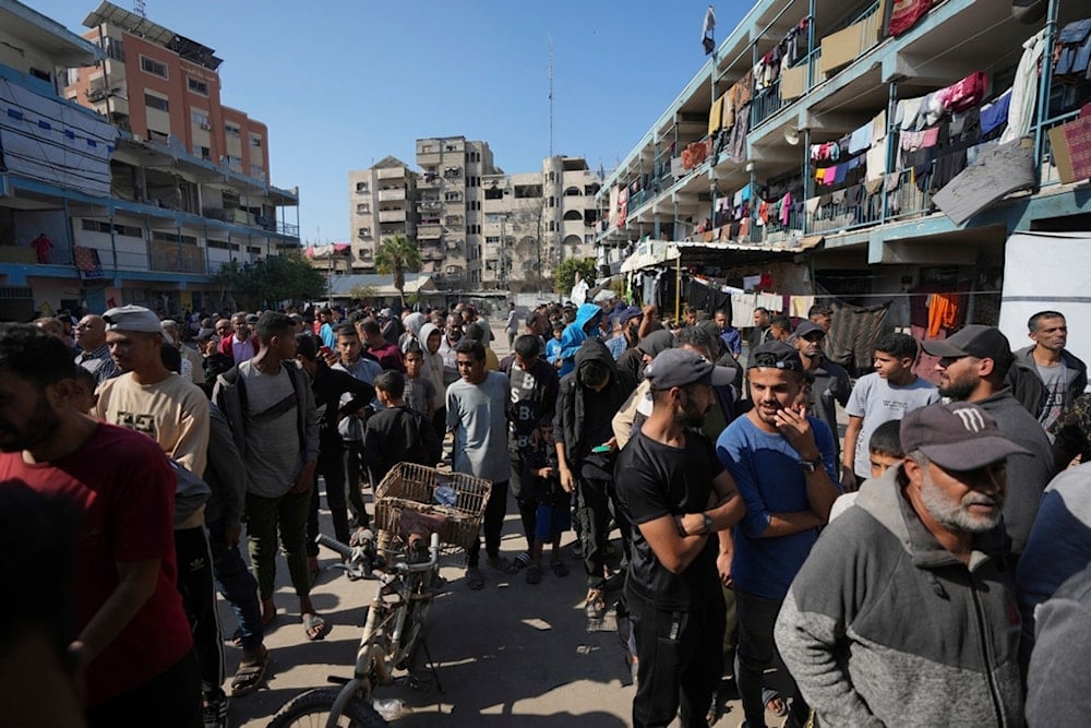 Palestinians gather to receive aid distributed by UNRWA, the UN agency helping Palestinian refugees, in Nusairat refugee camp, Gaza, on November 5, 2024 (AP)