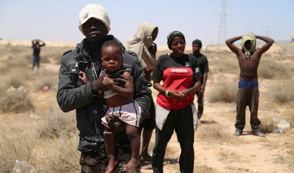 African migrants stand on the Libyan border with Tunisia on Thursday, Aug. 4, 2023. (AP)