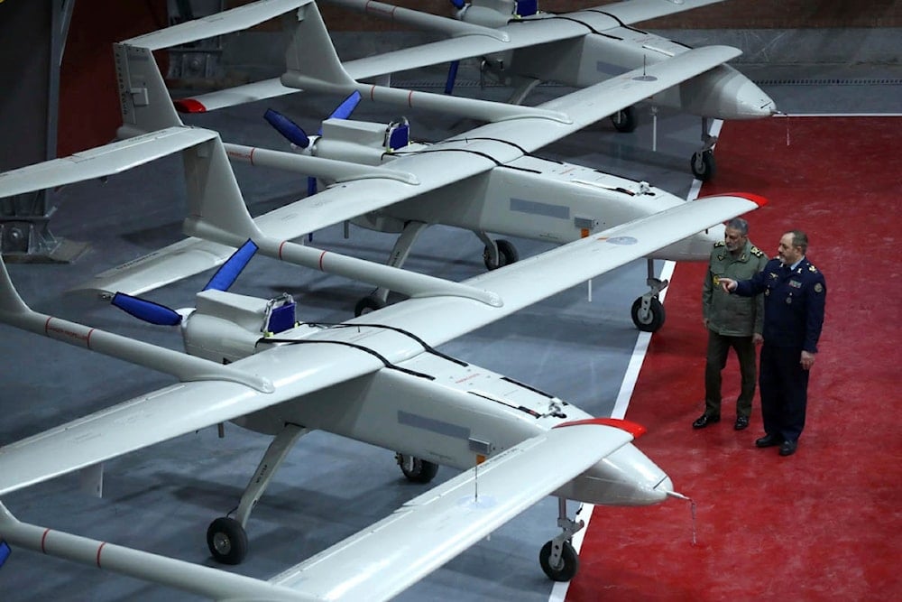 Iranian Defense Minister Gen. Aziz Nasirzadeh, right, speaks with the army commander Gen. Abdolrahim Mousavi in a ceremony to deliver domestically-built drones to the army on . (Iranian Army via AP)