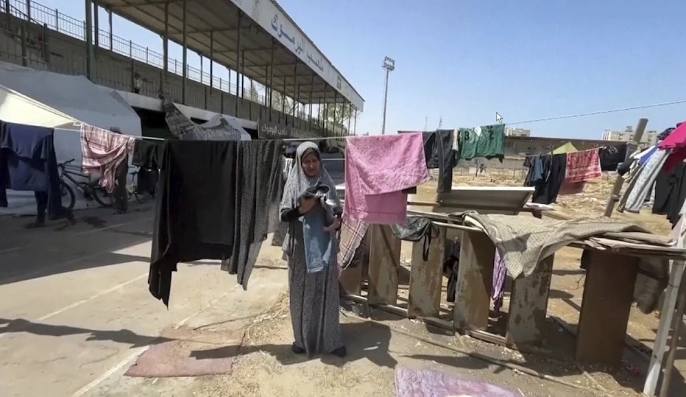 This image from video shows a woman drying clothes, Friday, July 5,2024 in Gaza city, Gaza Strip at Yarmouk Sports Stadium. (AP)