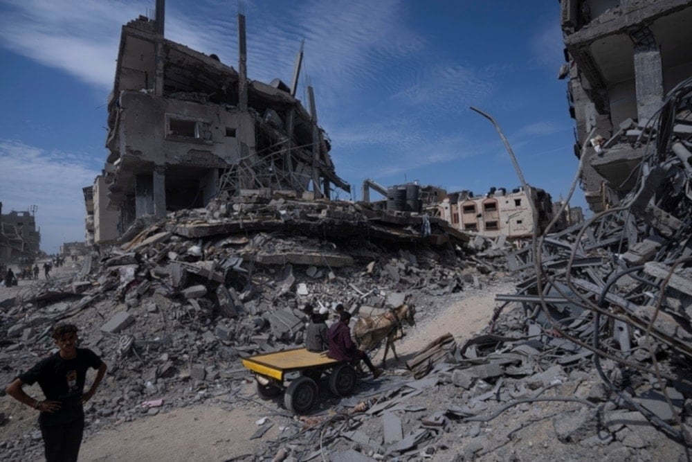 Palestinians walk through the destruction in the wake of the Israeli air and ground attack in Khan Younis, southern Gaza Strip, Palestine, April 8, 2024. (AP)