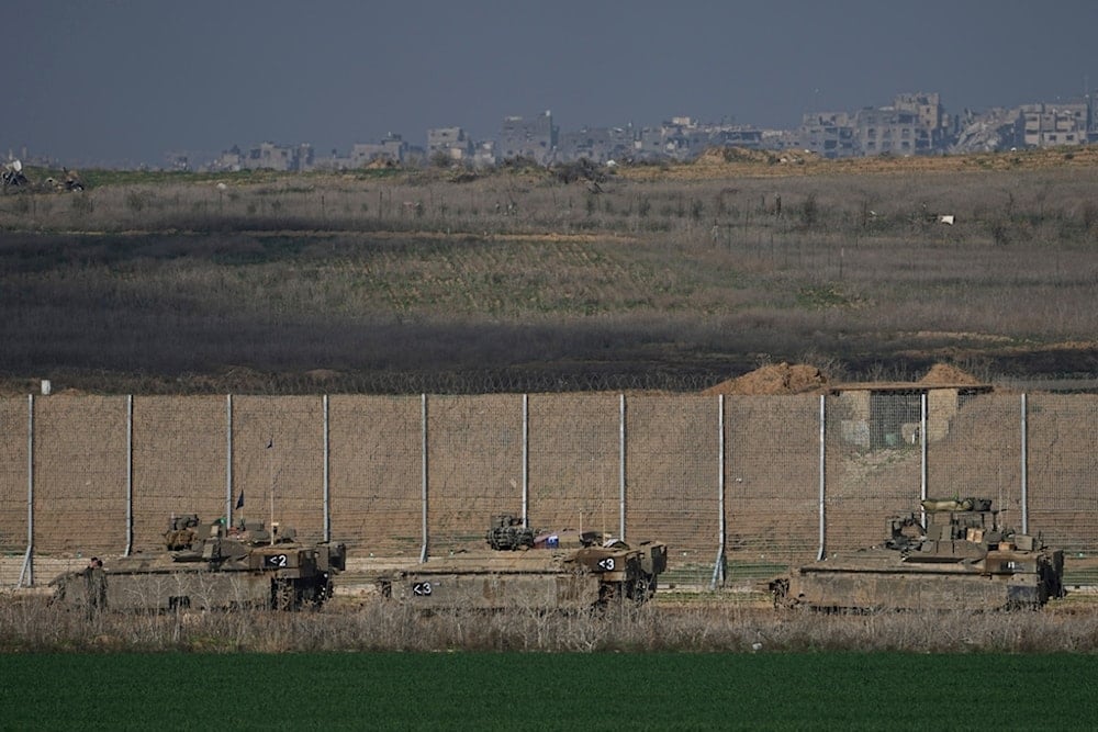 Israeli army APCs are moving along the separation line with the Gaza Strip in southern occupied Palestine, on Thursday, Jan. 16, 2025. (AP Photo/Tsafrir Abayov)