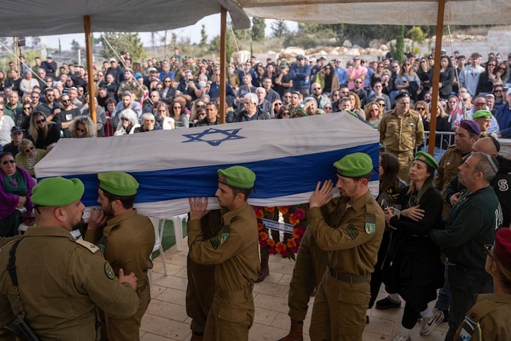 Israeli soldiers and relatives carry the flag-draped casket of Sergeant Yahav Maayan, who was killed in combat in the Gaza Strip, during his funeral at a military cemetery in Modiin, occupied Palestine, Sunday, Jan. 12, 2025 (AP)