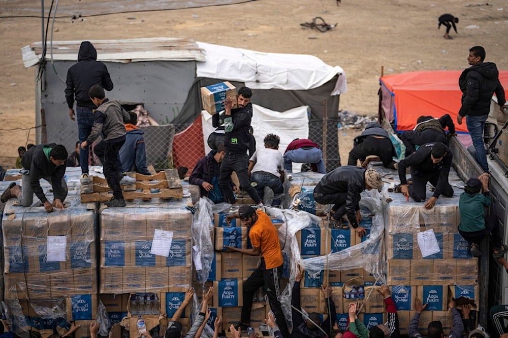 Palestinians grab humanitarian aid from a truck as it crossed into the Gaza Strip in Rafah, Dec. 17, 2023 (AP)