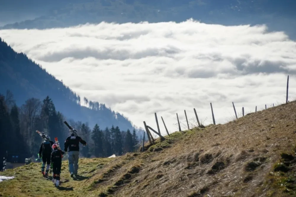 Tourists carry their skis on a snowless hill back to the resort of Leysin, in the Swiss Alps, on December 28, 2015Fabrice Coffrini (AFP)