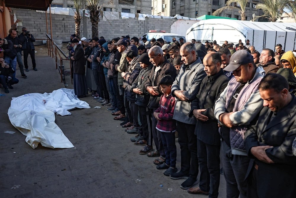 Mourners recite a prayer over the bodies of four people killed in an Israeli strike north of Khan Younis in the southern Gaza Strip, in the yard of the Nasser hospital on January 18, 2025 (AFP)